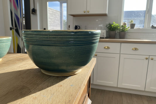 Green ceramic bowl on a wooden surface with a blurred background