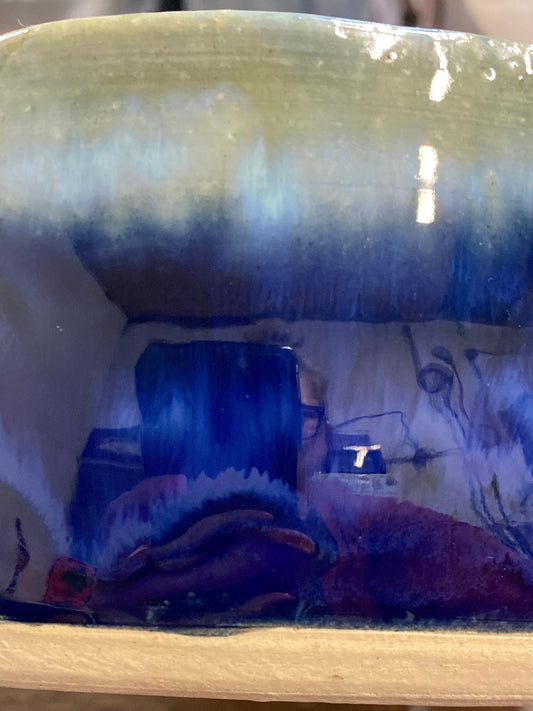 Decorative vase with floral pattern on a wooden shelf