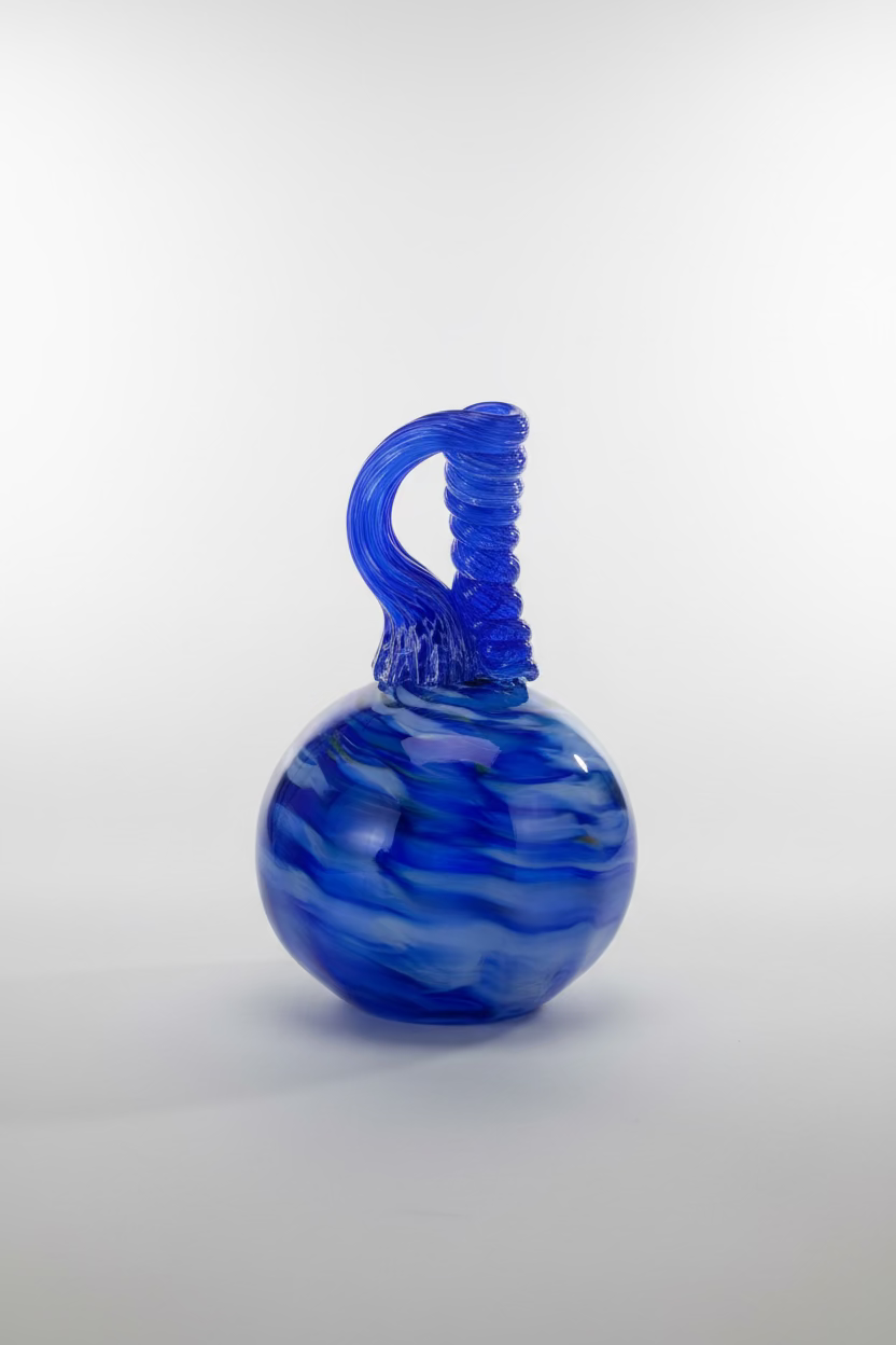 Blue glass vase with a unique design on a wooden table