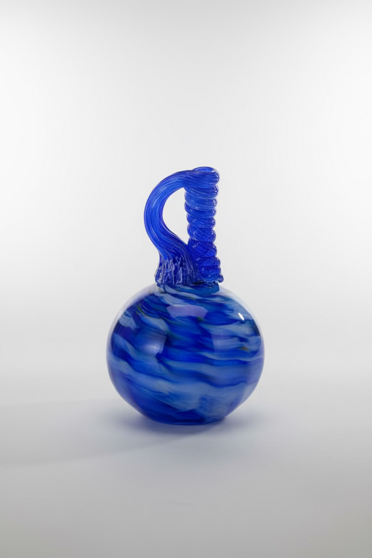 Blue glass vase with a unique design on a wooden table