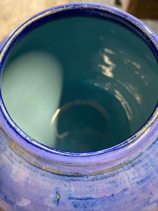 Close-up of a blue ceramic jar with a textured surface.