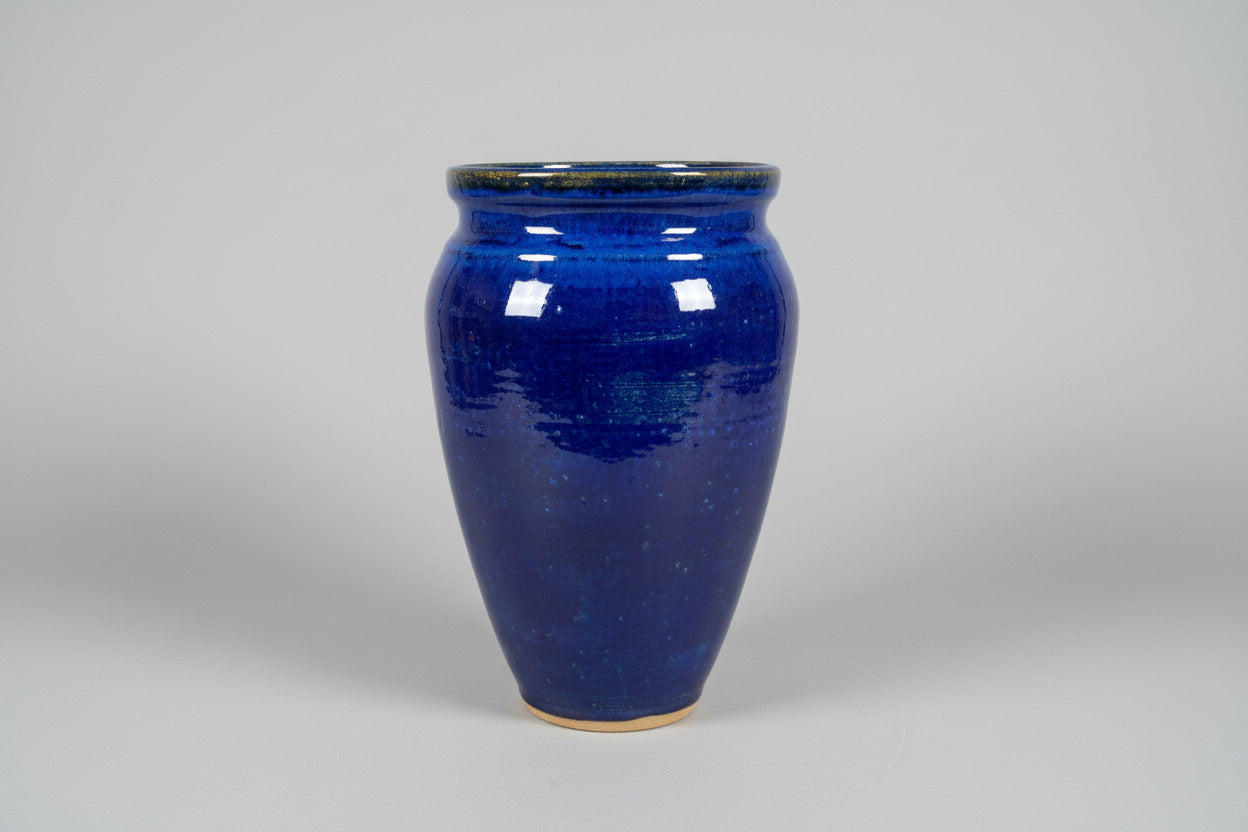 Blue ceramic mug on a wooden surface with a blurred indoor background